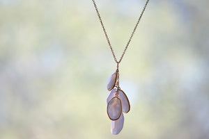 Colette Drill Cluster Five Stone Pendant Necklace in Chalcedony Pendant by Pippa Small is a  cluster of five organically shaped, lightly faceted and translucent pale lilac chalcedony stones of which three are bezel set and all are clustered on a chain in 18k yellow gold to form this necklace. 