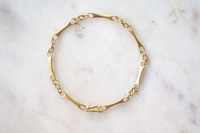 Marian Maurer City Bar Link Bracelet is a curved bone link in her signature smooth and silky 18k yellow gold with satin finish that honors New York City and cities.. This bracelet has a hook and eye closure with a safety to stay on forever.