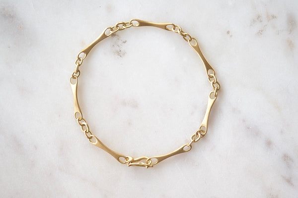 Marian Maurer City Bar Link Bracelet is a curved bone link in her signature smooth and silky 18k yellow gold with satin finish that honors New York City and cities.. This bracelet has a hook and eye closure with a safety to stay on forever.