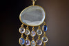 Raincloud Pendant Necklace by Pippa Small is a Large, faceted and transparent aquamarine with five rows of five stones each in blue to light purple hued tanzanite, aquamarine and kyanite bezel set stones in 18k yellow gold w extra long golden waxed cotton cord and accent bead for draping over head and no clasp.