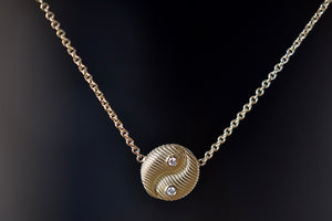 Retrouvai Mini All Gold Yin Yang Pendant with Diamonds  A unique modern take on an heirloom pendant. A beautifully textured and shaped gold disc accented with two (2) white diamonds hangs on a 16" 14k yellow gold chain.
