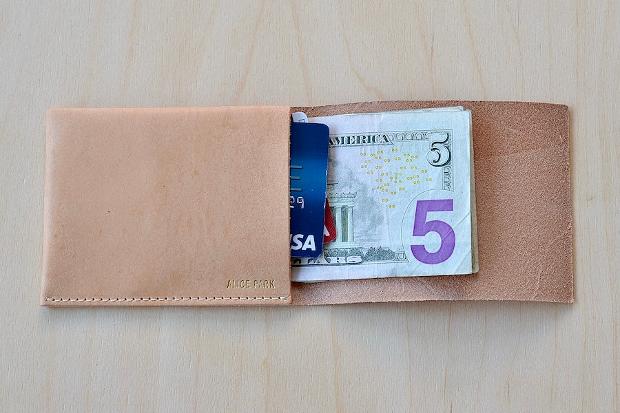 Simple Flap wallet in Natural leather and natural stitching from architect Alice Park shown open with cards and cash.