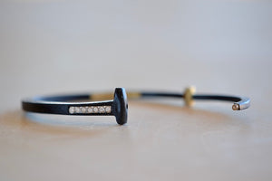 Pat Flynn Short Stripe Seven (7) Stone Bracelet is a Forged and tapered nail bracelet in blackened iron with seven accent diamonds on one side and completed with an 18k gold hinge and ball catch closure. Handcrafted in New York.