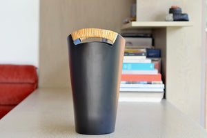 The Ørskov Wastebasket is made in matte black steel with cane wrapped handles and is 13" tall. It was designed by Grethe Kornerup-Bang in Denmark and is still  produced by Torben Orskow.