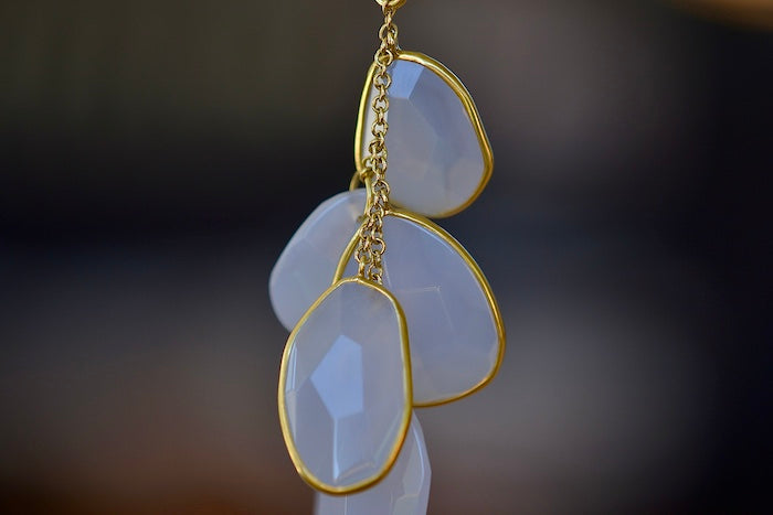 Colette Drill Cluster Five Stone Pendant Necklace in Chalcedony Pendant by Pippa Small is a  cluster of five organically shaped, lightly faceted and translucent pale lilac chalcedony stones of which three are bezel set and all are clustered on a chain in 18k yellow gold to form this necklace. 