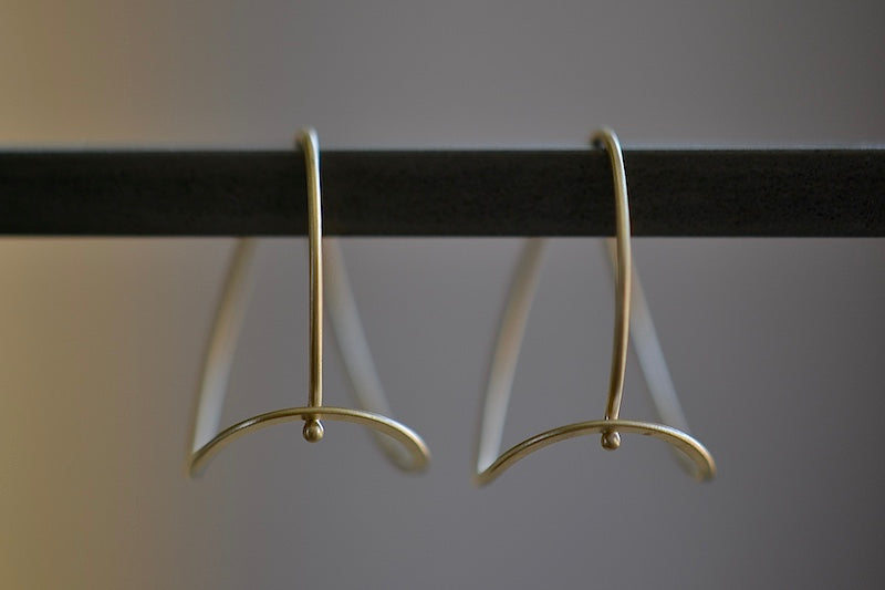 Carla Caruso Raindrop Hoop Earrings are Made from a single 14k gold wire with satin finish these shaped earrings have heft and a hook closure in the back.