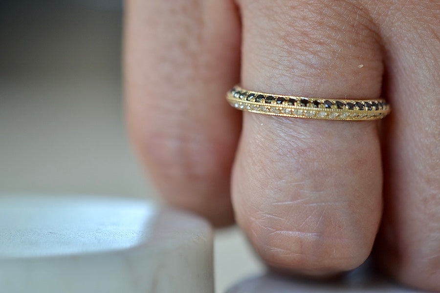 Lizzie Mandler The Othello Knife Edge Band ring by Lizzie Mandler is a wedding engagement band with White diamonds on one side and black round Diamond diamonds on the other in 18k yellow gold.