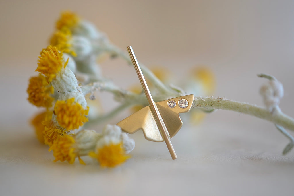 Kaylin Hertel single Lotus Stud earring in 14k yellow gold with two diamonds is made out of Abstract motif formed from creases of gold balanced on a stick.