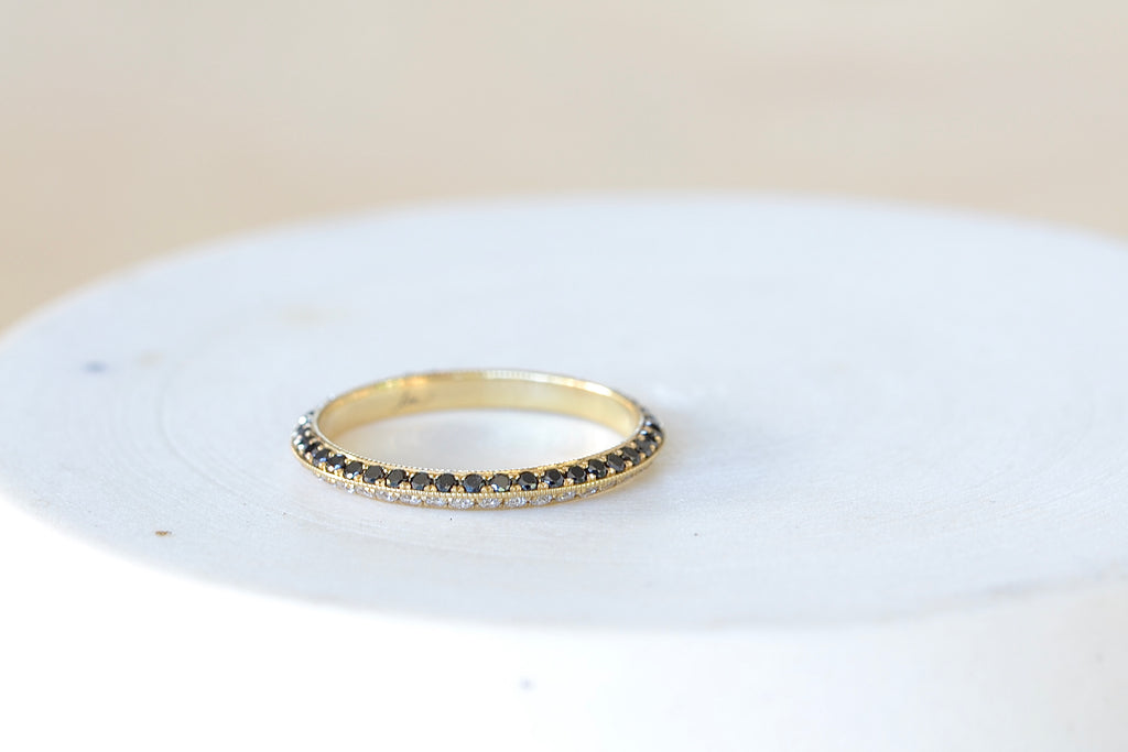 Lizzie Mandler The Othello Knife Edge Band ring by Lizzie Mandler is a wedding engagement band with White diamonds on one side and black round Diamond diamonds on the other in 18k yellow gold.