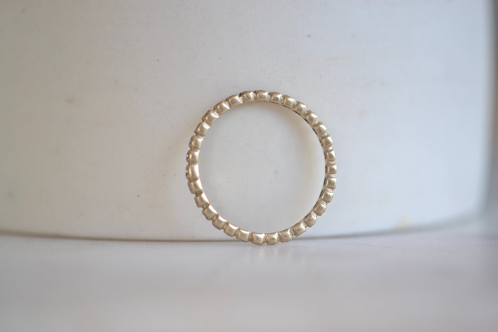 1mm thick porch band by Marian Maurer is a wedding band in bezel set round diamonds that is 1mm tall. In white gold.